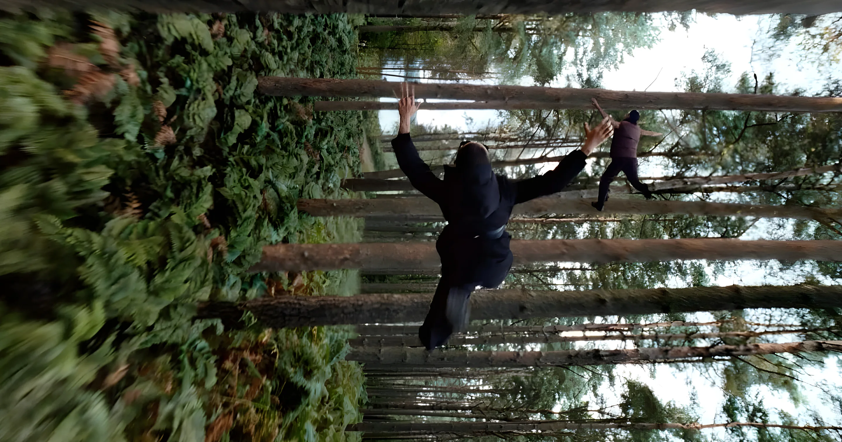Still from Burberry: Open Spaces. A figure leaps through a forest turned on its side.